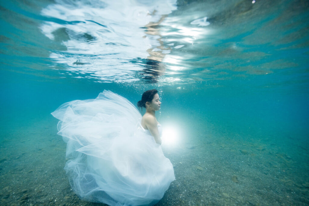 浅瀬の水中でドレスが広がる花嫁